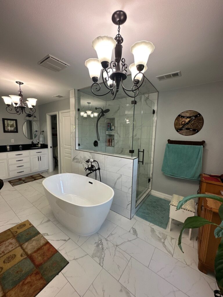 Primary bathroom remodel with glass shower, freestanding tub and chandelier